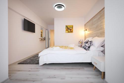 een slaapkamer met een wit bed met een houten hoofdbord bij Apartament Patrick in Gura Humorului