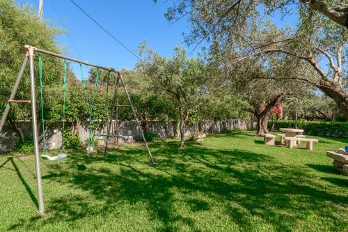 a playground with a swing in a yard at Evita Studios in Svoronata