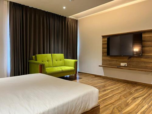 a hotel room with a bed and a flat screen tv at Hotel Tamarind Tree in Kharar