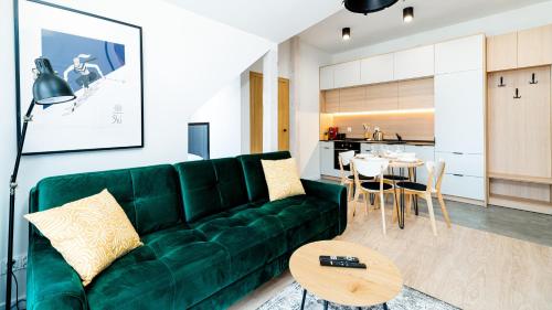 Una sala de estar con un sofá verde y una mesa. en Osada, Sun & Snow, en Szklarska Poręba