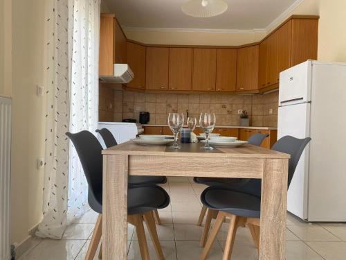 a dining room table with chairs and a white refrigerator at GnA Place in Zakynthos Town