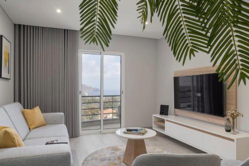ein Wohnzimmer mit einem Sofa und einem TV in der Unterkunft Barreiros III by An Island Apart in Funchal