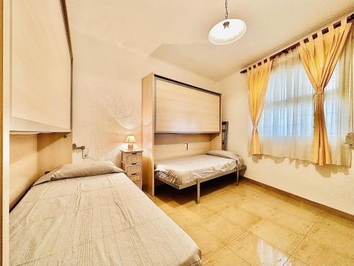1 dormitorio con 2 camas y ventana en Viamar Apartament, Costabravasi, en Santa Cristina d'Aro