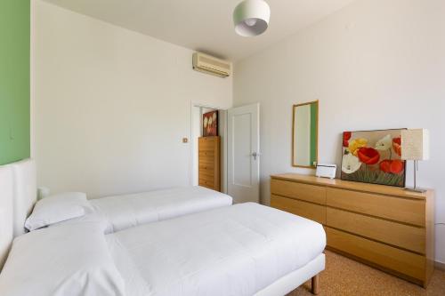ein weißes Schlafzimmer mit 2 Betten und einer Kommode in der Unterkunft Appartamento Ibisco by Wonderful Italy in Bologna