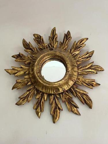 a gold sunburst mirror on a white background at Iconic Italian Townhouse w Rooftop Terrace & Mountain View, Pigna in Pigna