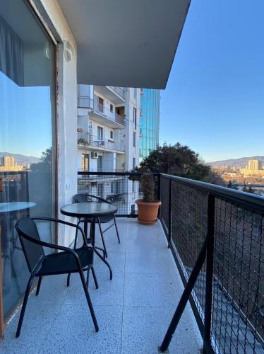 a balcony with a table and chairs on a building at Kobi Apartments in Tbilisi City