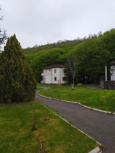 a road leading to a white house in a yard at Qusar Qala Hotel in Qusar