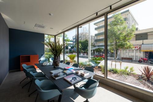 a dining room with a table and chairs and a large window at Hotel Sporting Riccione in Riccione