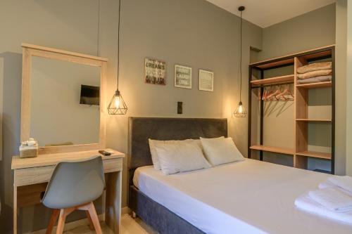 a bedroom with a bed and a desk and a chair at Evita Studios in Svoronata
