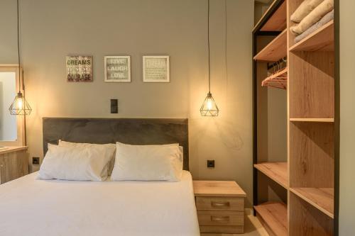 a bedroom with a bed with white pillows and shelves at Evita Studios in Svoronata