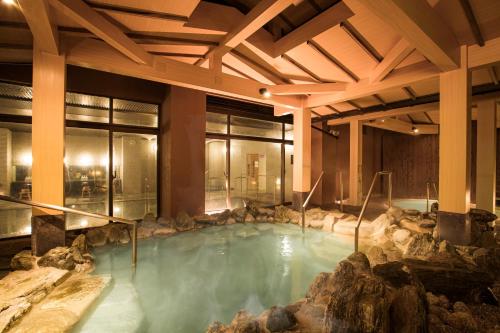 Toba International Hotel Shiojitei في توبا: تجمع كبير للمياه مع الصخور في المبنى