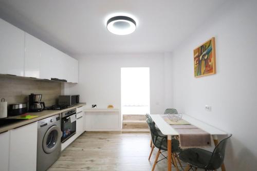 een keuken met een tafel en stoelen en een keuken met een fornuis bij Apartament Patrick in Gura Humorului