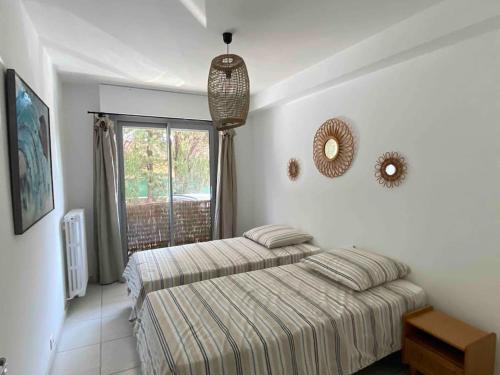 une chambre avec un lit et une grande fenêtre dans l'établissement Cocon les pieds dans l'eau Accès direct à la mer, à La Ciotat