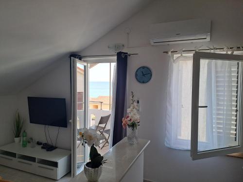 a living room with a clock and a window at Son de Mar Novalja-Pag Apartment in Novalja