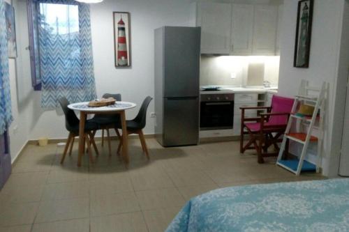 a kitchen and dining room with a table and chairs at Vourkari Studio 2 with kitchen in Ioulida
