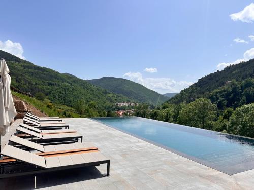 una piscina con vistas a la montaña en Hotel Rural-Spa Resguard Dels Vents en Ribes de Freser