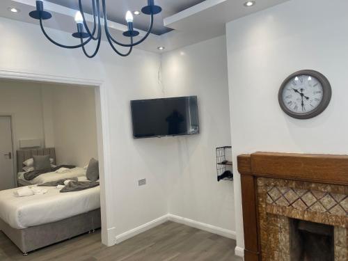 a living room with a clock on the wall and a fireplace at Araan House Hotel -Families and Couples Only in Blackpool