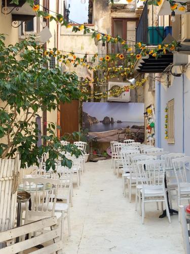 a row of white tables and chairs in a courtyard at Le Plejadi in Castellammare del Golfo