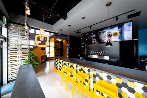 restauracja z żółtymi krzesłami i barem w obiekcie The Villa & Barrel Lounge w mieście Shizuoka