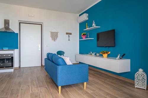 un salon bleu avec un canapé bleu et une télévision dans l'établissement Maranto Vista - YourPlace Abruzzo, à Fossacesia