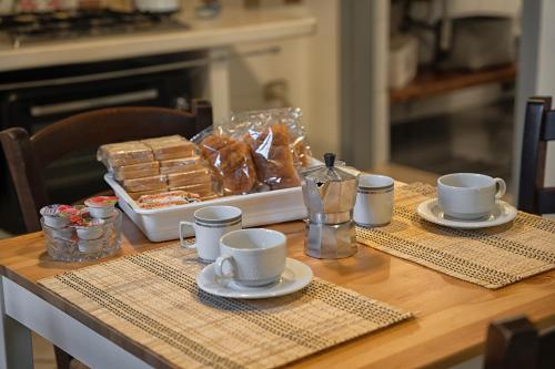 een tafel met twee kopjes en een doos brood bij Sunshine House - Ostuni BB di Antonella in Ceglie Messapica