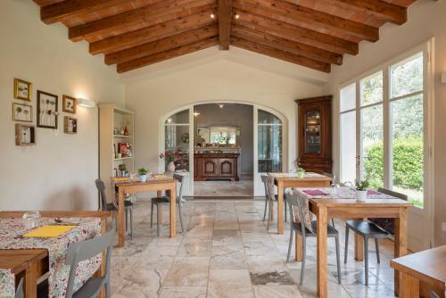 uma sala de jantar com mesas e cadeiras de madeira em Agriturismo Tra gli Ulivi, Chiappini em Bolgheri