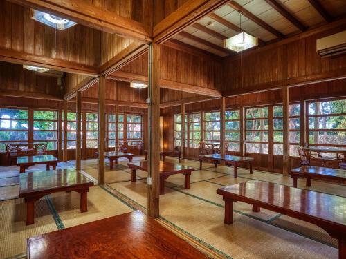 uma sala vazia com mesas e janelas de madeira em Hotel Murasakimura em Yomitan