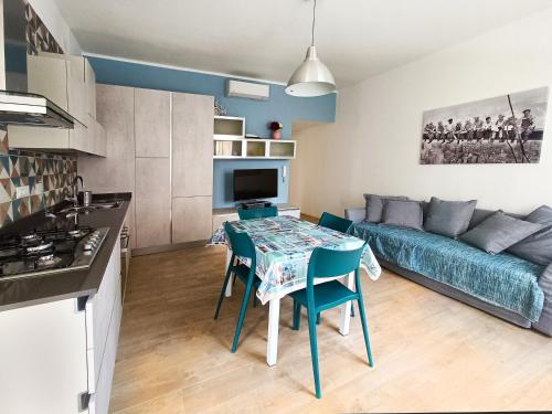 uma cozinha e sala de estar com uma mesa e um sofá em Incantevole Appartamento Genova Quinto vicino alla spiaggia em Génova