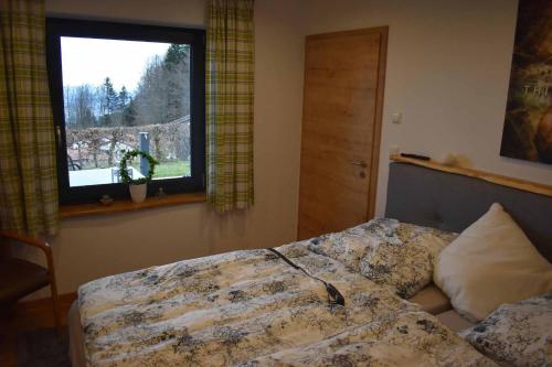 a bedroom with a bed and a window at Ferienhaus AlpenBlick in Schöfweg