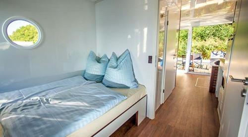 a bedroom with a bed with blue pillows on it at KUHNLE-TOURS Kabinen in Rechlin