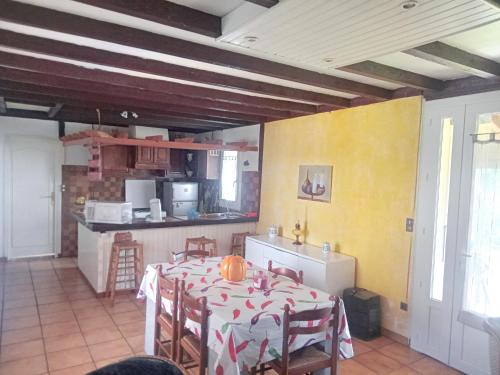 une cuisine avec une table et des chaises dans une pièce dans l'établissement Maison de charme à Arnaud-Guilhem avec vue sur la montagne, à Arnaud-Guilhem