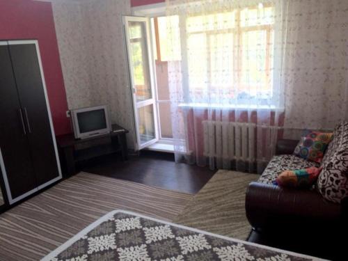 a living room with a couch and a tv at ЛЮКС на Юго-востоке,Степной1 in Karagandy