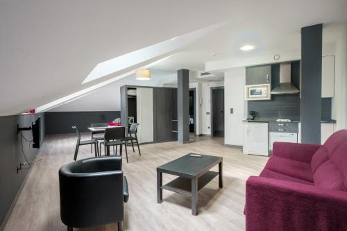 sala de estar con sofá púrpura y mesa en Apartamentos Capua, en Gijón