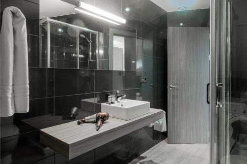 a bathroom with a sink and a mirror at Apartamentos Capua in Gijón