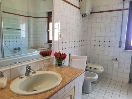 a white bathroom with a sink and a toilet at Appartamenti Orchidea in Tropea