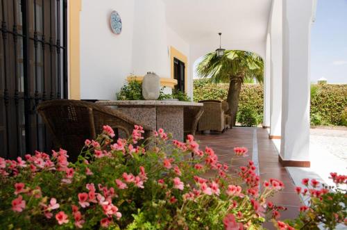 a patio with pink flowers and a table and chairs at Villa Vacacional Los Naranjos in Montemayor