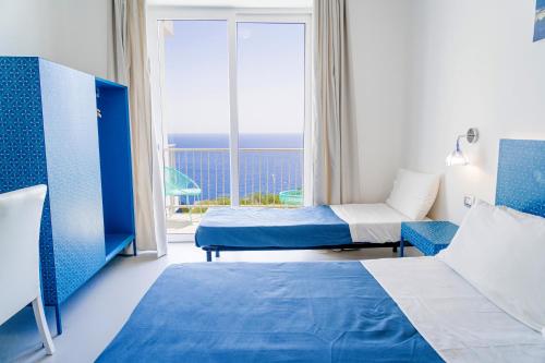 a hotel room with two beds and a view of the ocean at Hotel Orsa Maggiore in Castro di Lecce