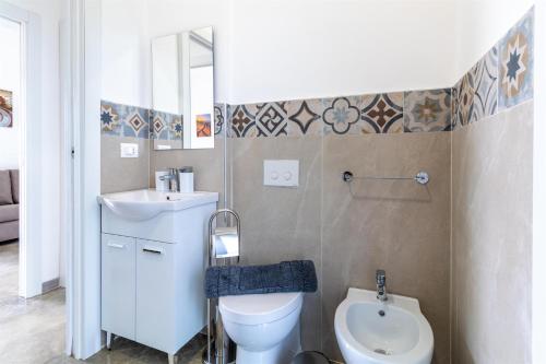 a small bathroom with a toilet and a sink at Verde Oliva Residence in Ispica