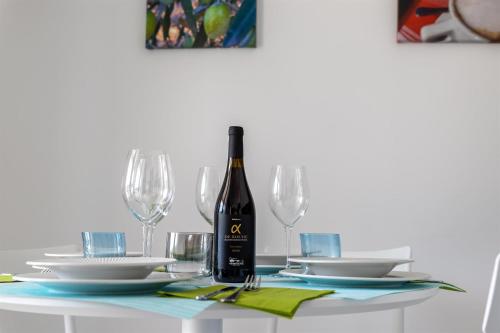 a bottle of wine sitting on a table with glasses at Verde Oliva Residence in Ispica