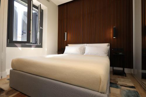 a bedroom with a large white bed and a window at Renovated & fully equipped-Luxurious-2Room Fontana Suite, it just doesn't get any better! in Olbia