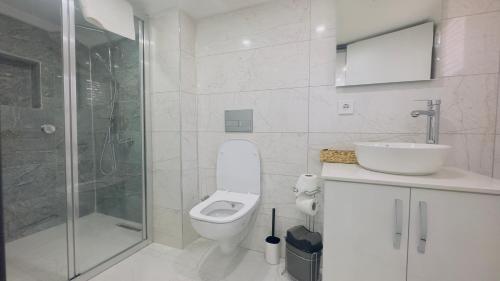 y baño blanco con aseo y ducha. en La Mer Old City Hotel en Estambul