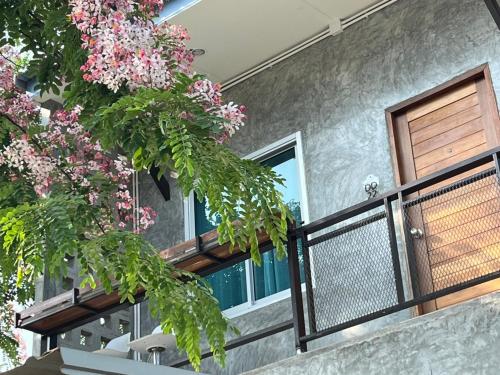 a house with a balcony with pink flowers at บ้านพักบุหงา199 แฟมิลี่ อ สรรพยา 