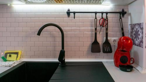 une cuisine avec un évier noir et des ustensiles de cuisine dans l'établissement Home Corinto Beach terraza y piscina - Benalmadena Malaga, à Benalmádena