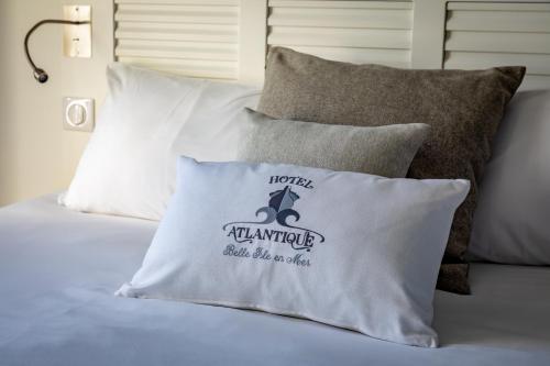 a pile of pillows sitting on top of a bed at Hotel Atlantique in Le Palais