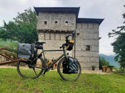 una bicicleta estacionada frente a una torre de piedra en Kulla Hupi Agriturism, en Bulqizë