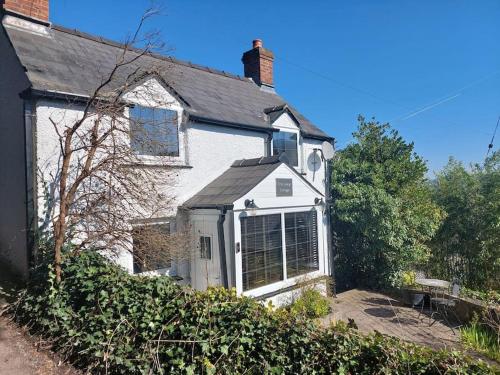 a white house with a window on the side of it at Crossways Cottage & hot tub - Symonds Yat in Symonds Yat