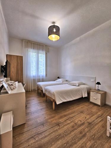 a bedroom with two beds and a large window at La Ca' Bianca Affittaly Rooms in Castenaso