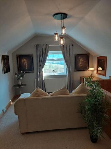 a living room with a couch and a window at Crossways Cottage & hot tub - Symonds Yat in Symonds Yat