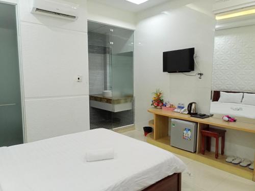 a bedroom with a bed and a tv on the wall at VẠN LỘC HOTEL in Can Tho