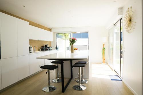 eine Küche mit einem Tisch und Stühlen in der Unterkunft EXIGEHOME- Maison d'architecte avec SPA - V2 in Orgeval